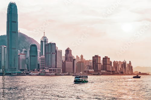 Star ferry in Victoria Harbor and Hong Kong skyline at sundown