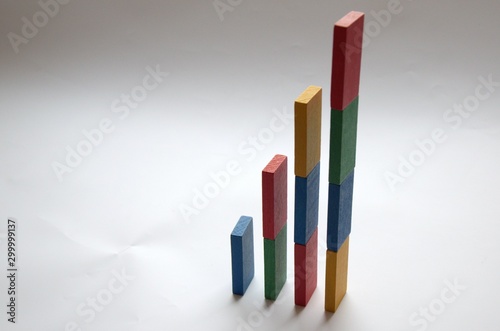  91 / 10000 АНГЛИЙСКИЙ Перевести вGoogleBing The growth chart in the business is depicted from dominoes of red, blue, yellow and green.