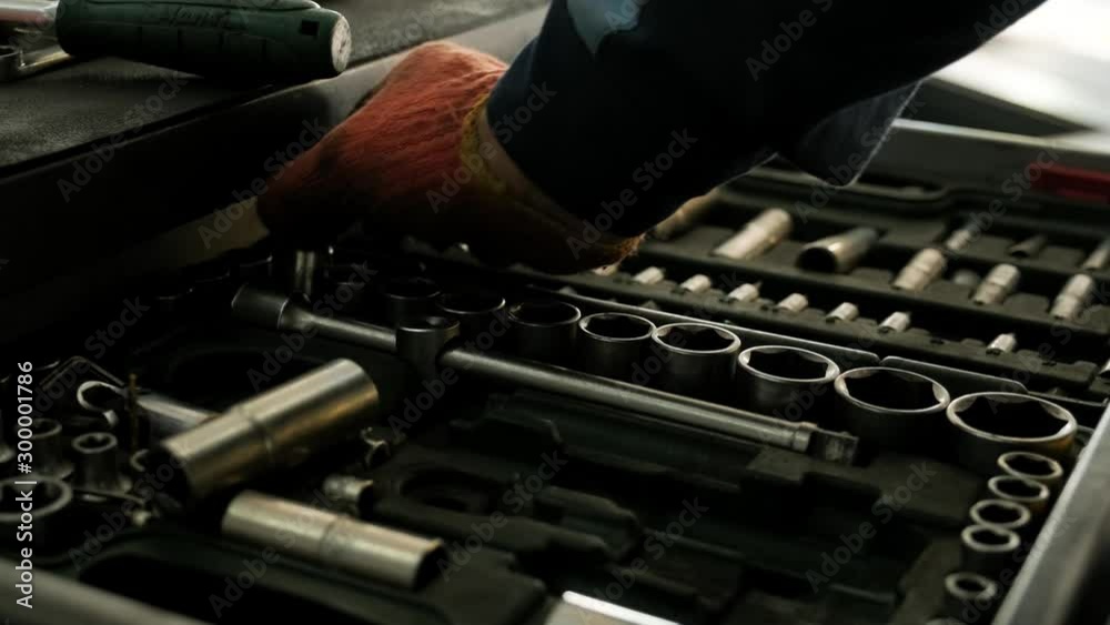 A set of tools for repair in car service - mechanic's hands, close up