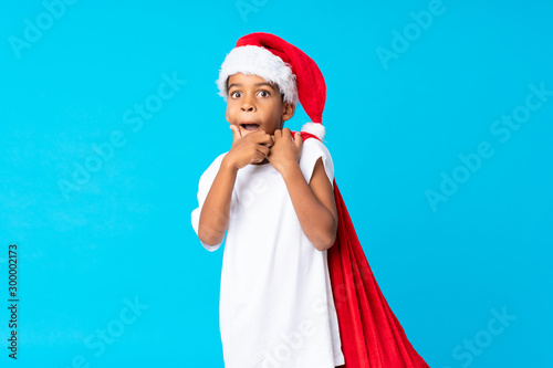 African American boy with christmas hat and taking a bag with gifts