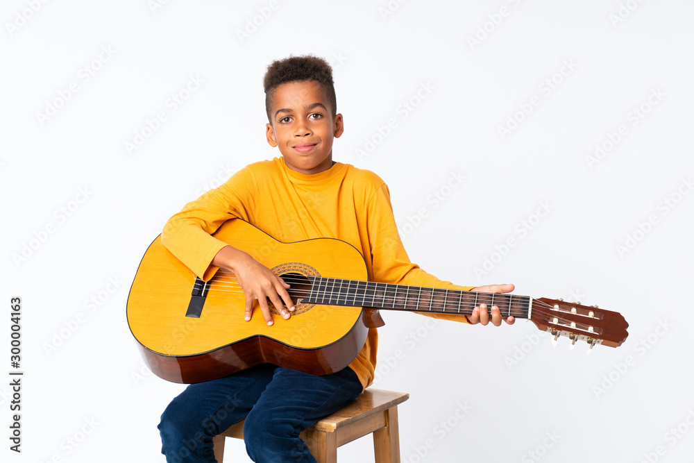 African American boy with guitar over isolated white background African American boy with guitar over isolated white background