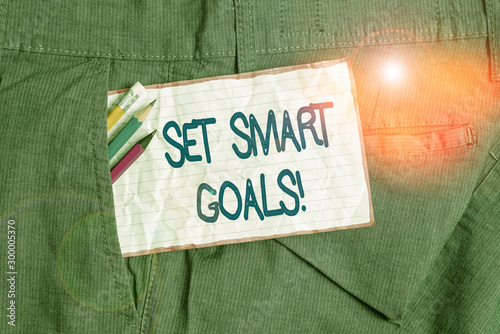 Text sign showing Set Smart Goals. Business photo text list to clarify your ideas focus efforts use time wisely Writing equipment and white note paper inside pocket of man work trousers