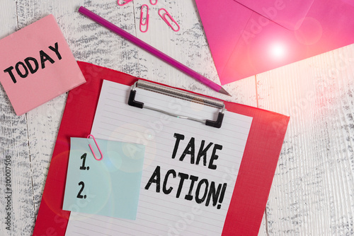 Word writing text Take Action. Business photo showcasing do something official or concerted to achieve aim with problem Clipboard paper sheet pencil note envelope clips notepad wooden background