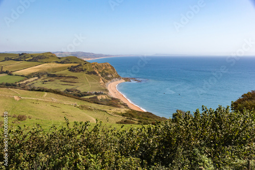 Far reaching view out to the English Channel sea from the top of Golden Cap in West Dorset, England, with background view of Bridport sandstone cliffs and Chesil beach stretching in to the distance photo