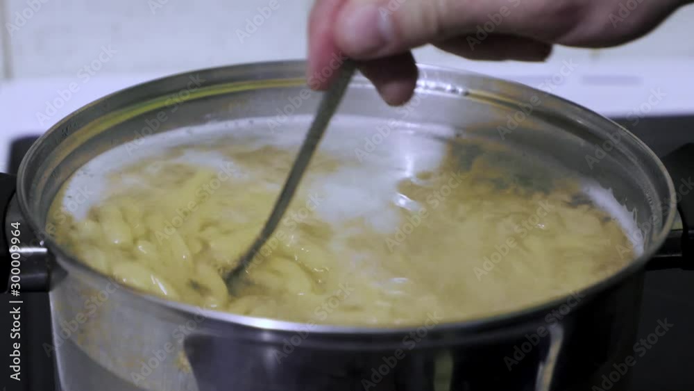 Hand of a lonely man cooks pasta closeup Hand of a lonely man cooks pasta closeup
