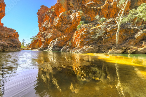 Red cliffs reflected in a permanent waterhole. Ellery Creek Big Hole is one of most popular camping, walking, swimming spots in West MacDonnell Ranges, Northern Territory on Larapinta Trail, Australia photo