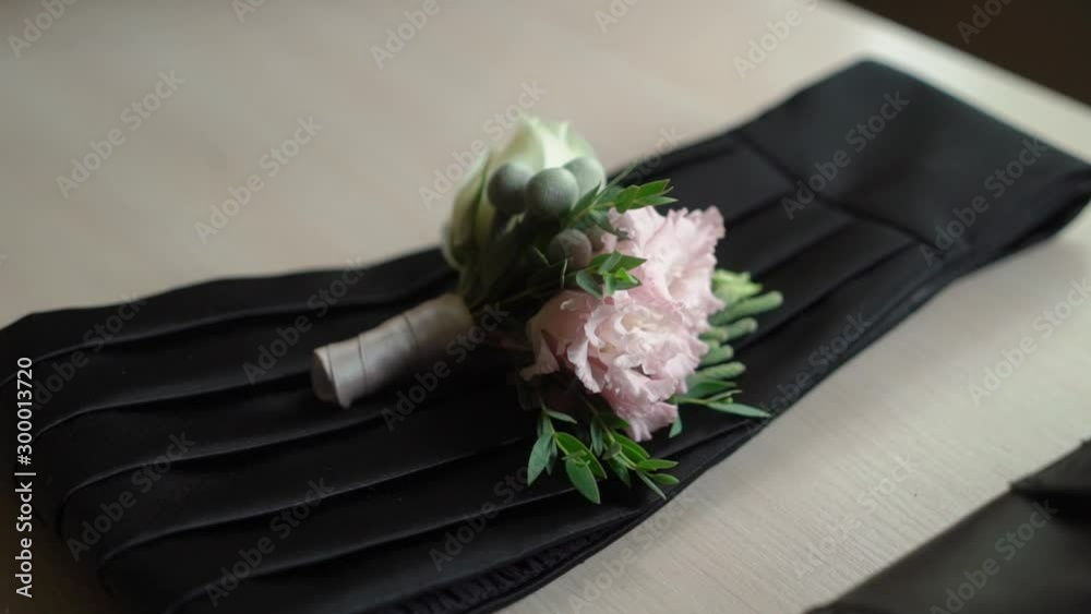Man's accessories - boutonniere, belt for tuxedo. Groom fashion for wedding