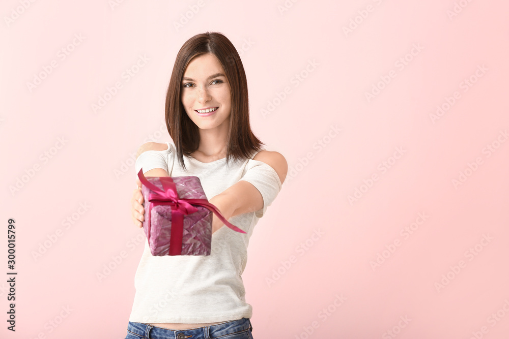 Beautiful young woman with gift on color background Beautiful young woman with gift on color background