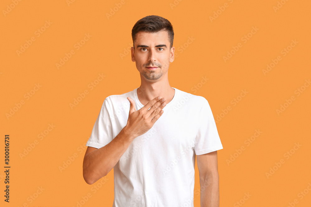 Young deaf mute man using sign language on color background Young deaf mute man using sign language on color background