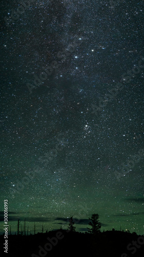 Obraz na płótnie Universe against the background of the emerald sky. Dark hills and burnt trees after the eruption of Tolbachek volcano in Kamchatka, Russia w salonie