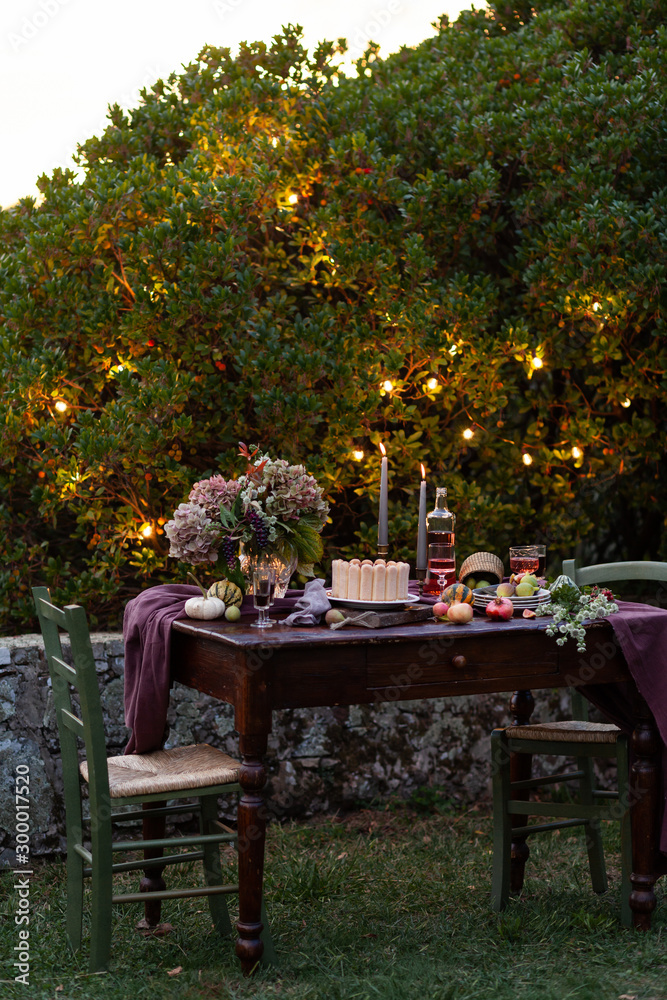 Beautiful and elegant table setting for a romantic date for a couple. Private terrace outside the restaurant. Lights on background Beautiful and elegant table setting for a romantic date for a couple. Private terrace outside the restaurant. Lights on background