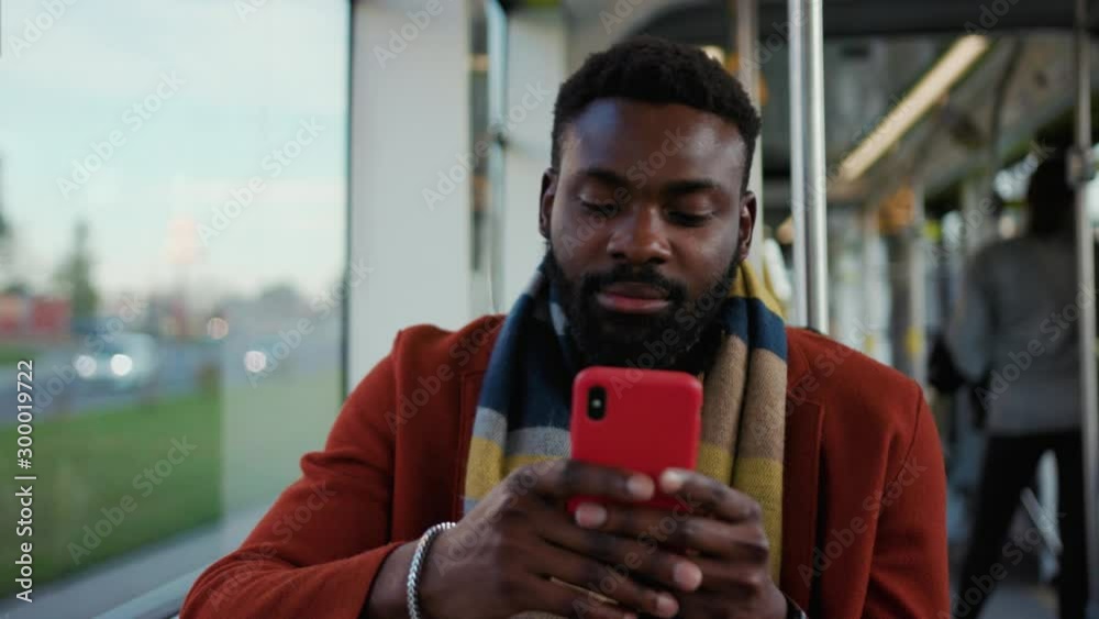 Close up serious portrait african american man use smartphone sitting in tram traffic typing handsome passangers stylish transportation using way internet online texting guy slow motion