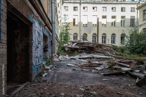 The city's old abandoned yard with a lot of garbage and walls covered with