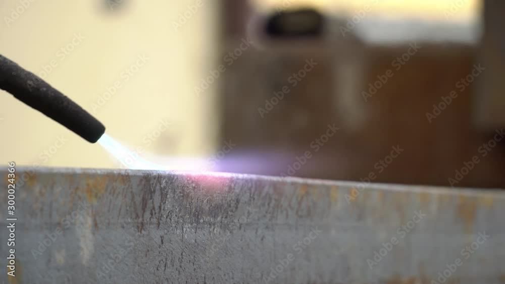 Cutting a steel profile with an acetylene torch. Heating a steel element with a cutting torch. Cutting a steel profile with an acetylene torch. Heating a steel element with a cutting torch.