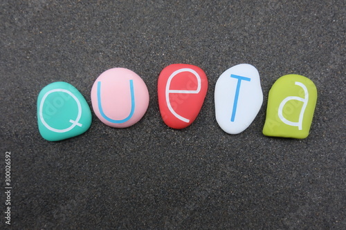 Queta, female given name composed with colored and carved stones over black volcanic sand photo