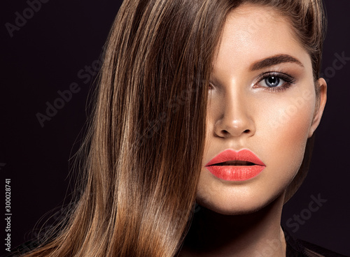 Woman with beauty long brown hair. Beauty woman with living coral color lipstick on lips.