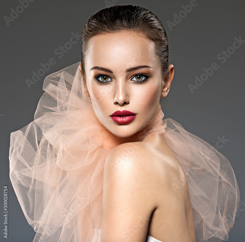 Beautiful woman with  red lips wearing beige scarf photo