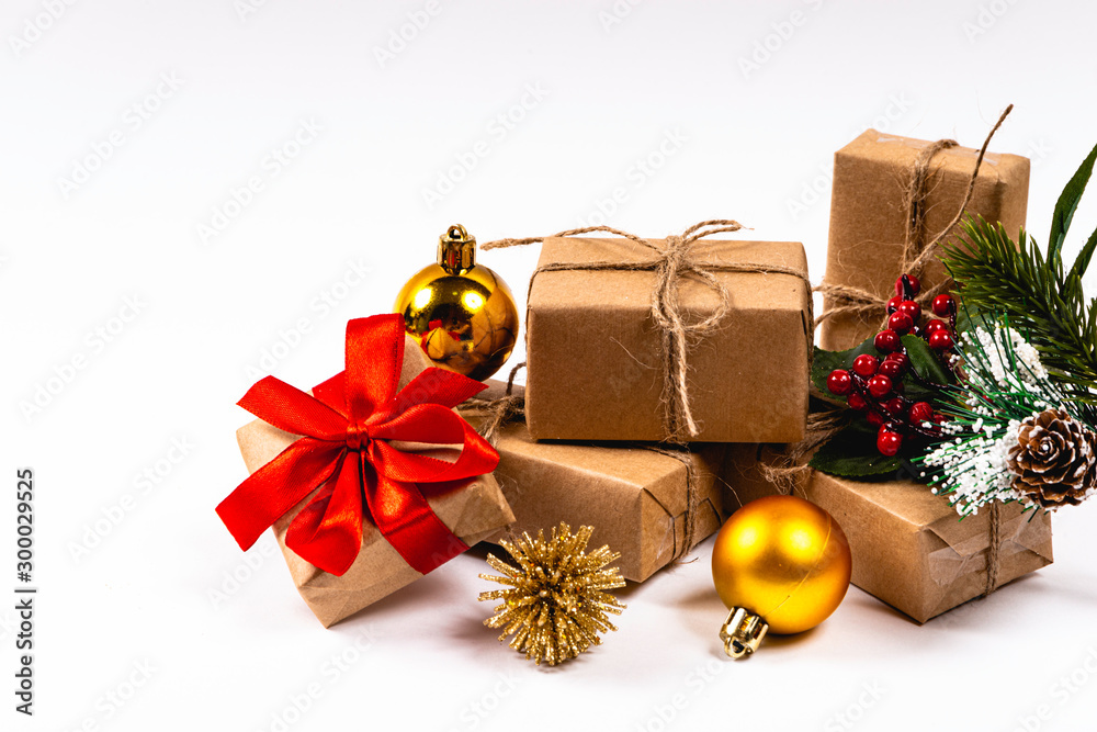 Several gifts in beige color stacked on white background with Christmas ornaments. Christmas concept.