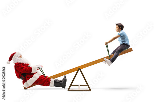 Santa Claus playing on a seesaw with a boy and laughing