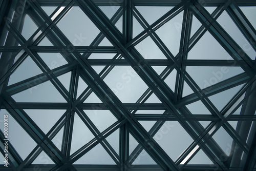Reworked photo of backlit structural glazing. Modern architecture fragment. Glass ceiling, roof or wall with template of transparent panels. Abstract geometric background with polygonal pattern.