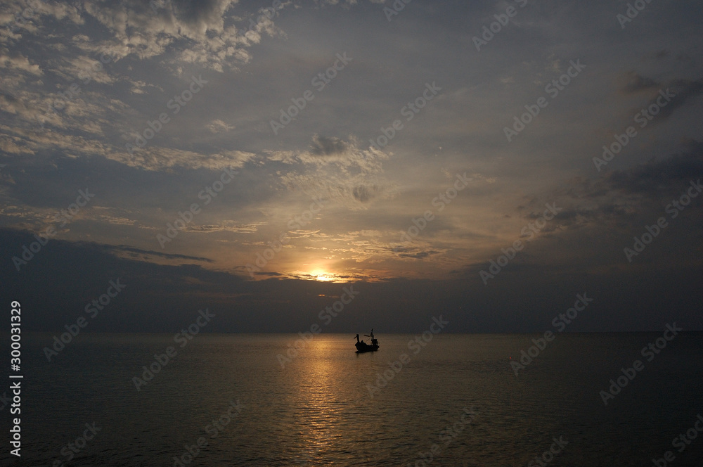 A boat in the calm seas at Mai Khao Beach, Phuket, Thailand A boat in the calm seas at Mai Khao Beach, Phuket, Thailand