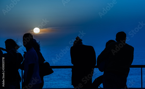 sunset on the middle of the mediterean sea with the silhouette of people  photo