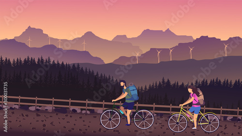Cyclists ride a country road with mountain views in summer