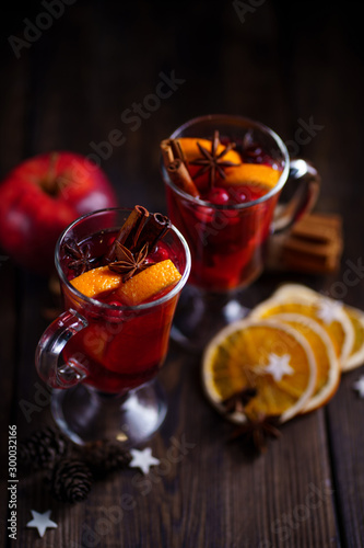 Christmas mulled spiced wine with cranberry and oranges. Traditional hot winter drink, festive beverage with Xmas or New Year decorations
