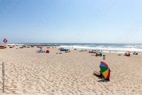 View at the beach with people taking sunbath on beach. Atlantic Ocean, Costa Nova, Portugal