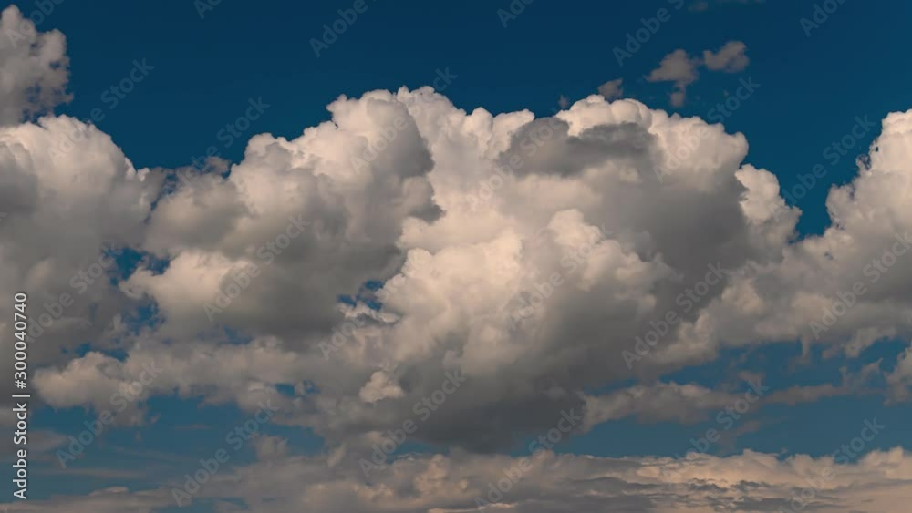 Time lapse of puffy billowing beautiful white cumulus clouds building up and drifting across a brilliant blue sky. Time lapse of puffy billowing beautiful white cumulus clouds building up and drifting across a brilliant blue sky.