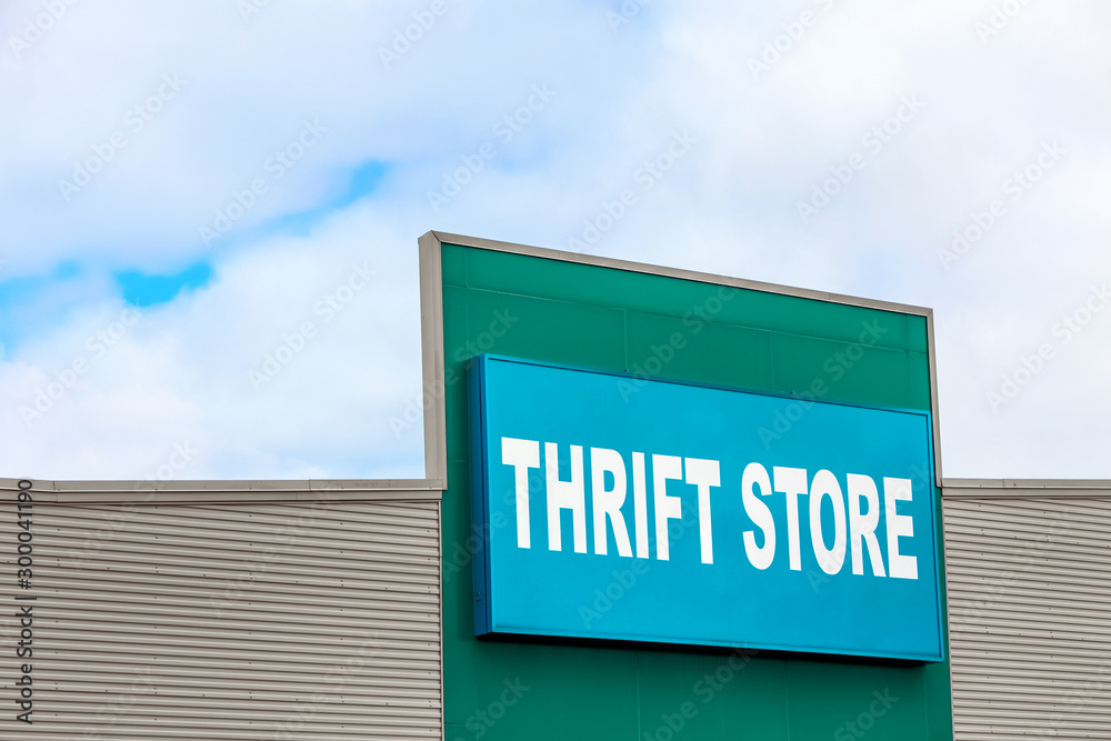 Thrift store sign on the side of a building against a blue sky Thrift store sign on the side of a building against a blue sky