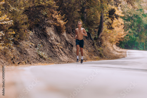 Male athlete fitness runner sprinting fast outside.Trail running concept © qunica.com