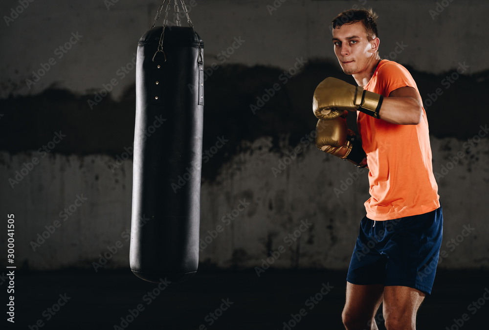 Hispanic MMA Fighter practicing some kicks with a punching bag Hispanic MMA Fighter practicing some kicks with a punching bag