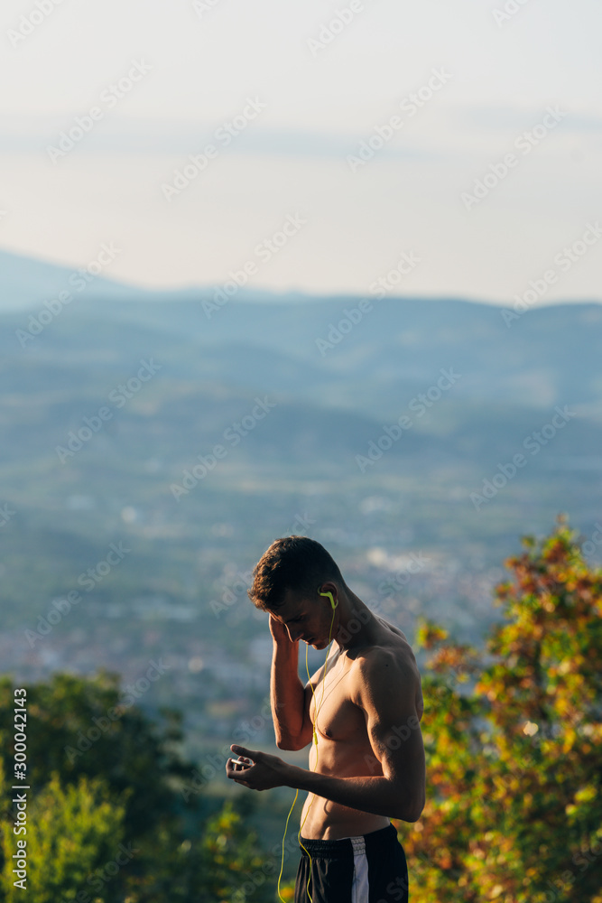 Sportive guy searching music on mobile while prepare for run Sportive guy searching music on mobile while prepare for run