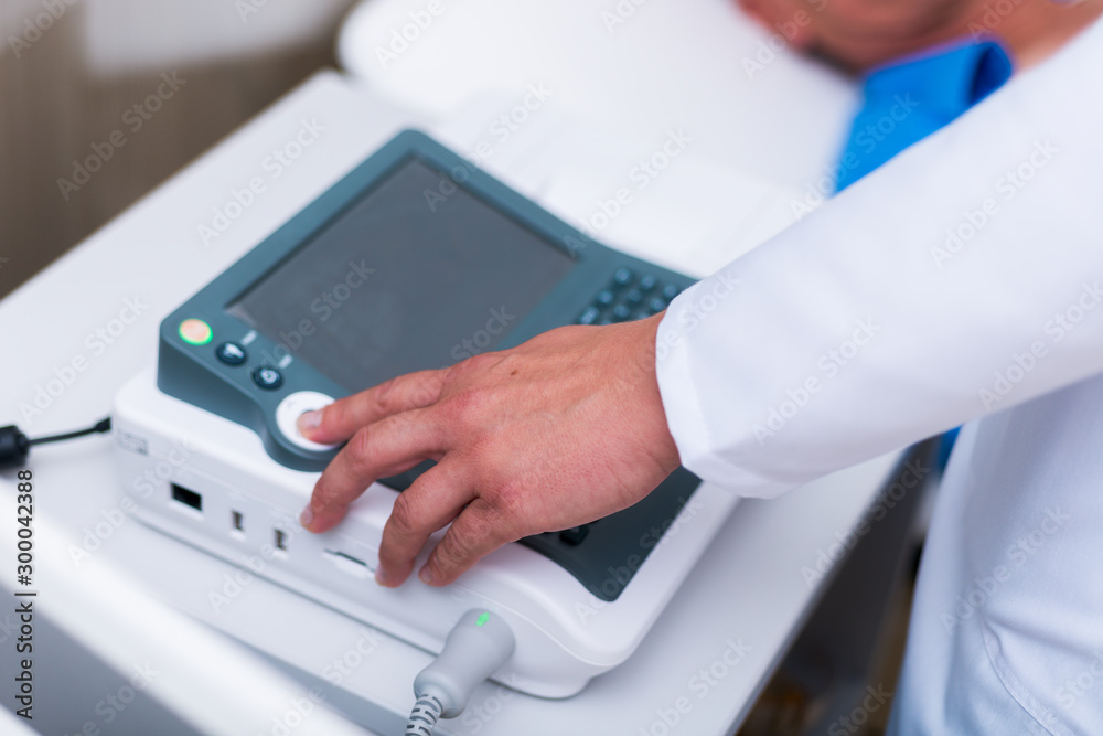 Close up photo on a EKG machine while an older man gets his heart checked. Close up photo on a EKG machine while an older man gets his heart checked.
