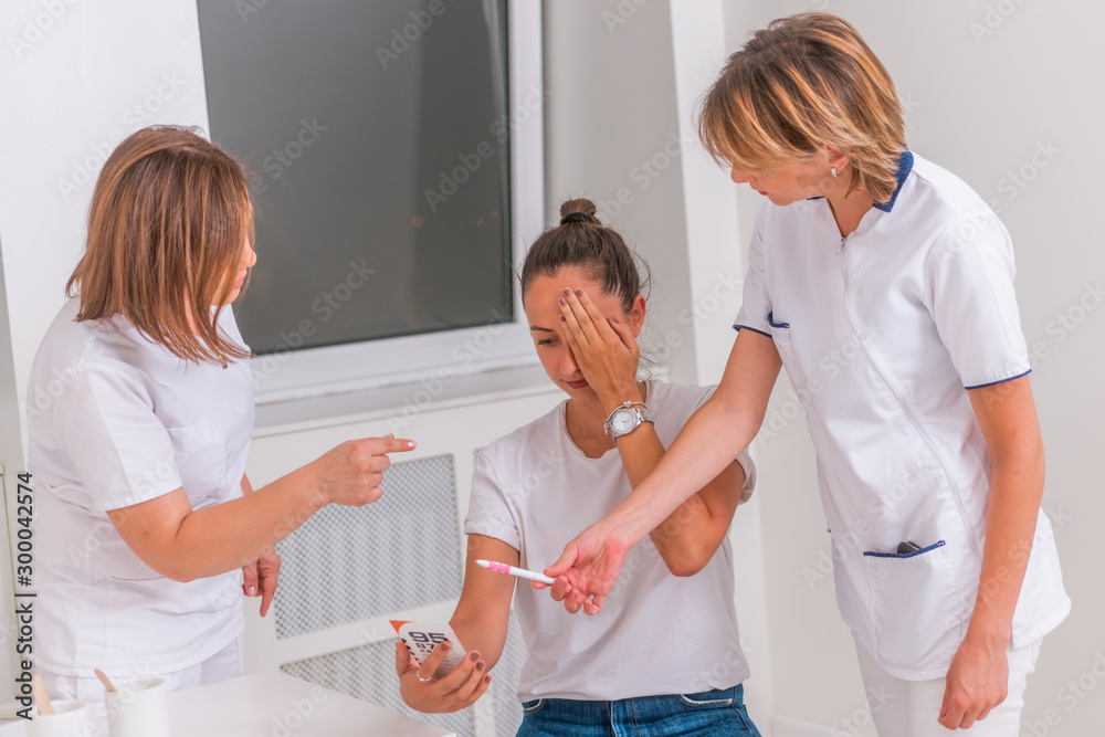 Obraz premium Woman ( girl )reviewing eyesight closing eye with hand. Eye test. Eyesight vision exam chart. Close up on a Snellen char