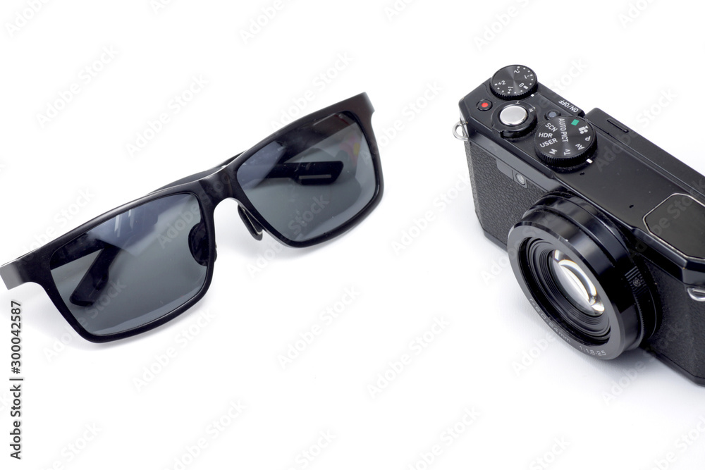 Black camera and sunglasses on a white isolated background Black camera and sunglasses on a white isolated background