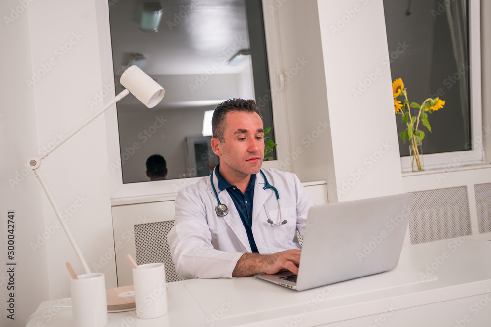 Portrait of Doctor specialist sitting on a chair at his desk while working. Portrait of Doctor specialist sitting on a chair at his desk while working.