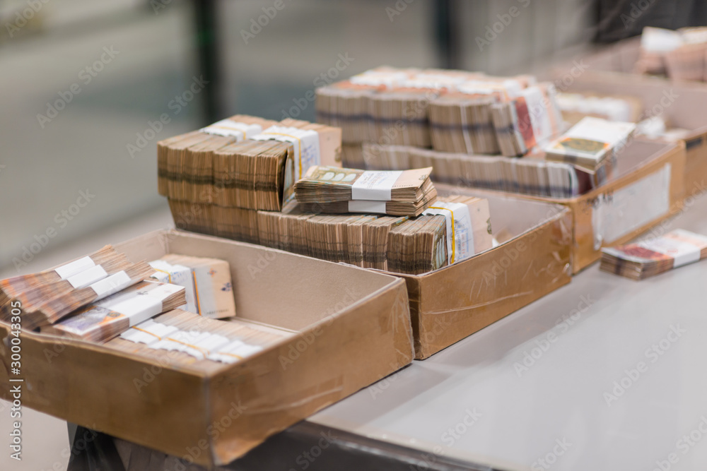 Vast amount of cash with currency bands placed into boxes