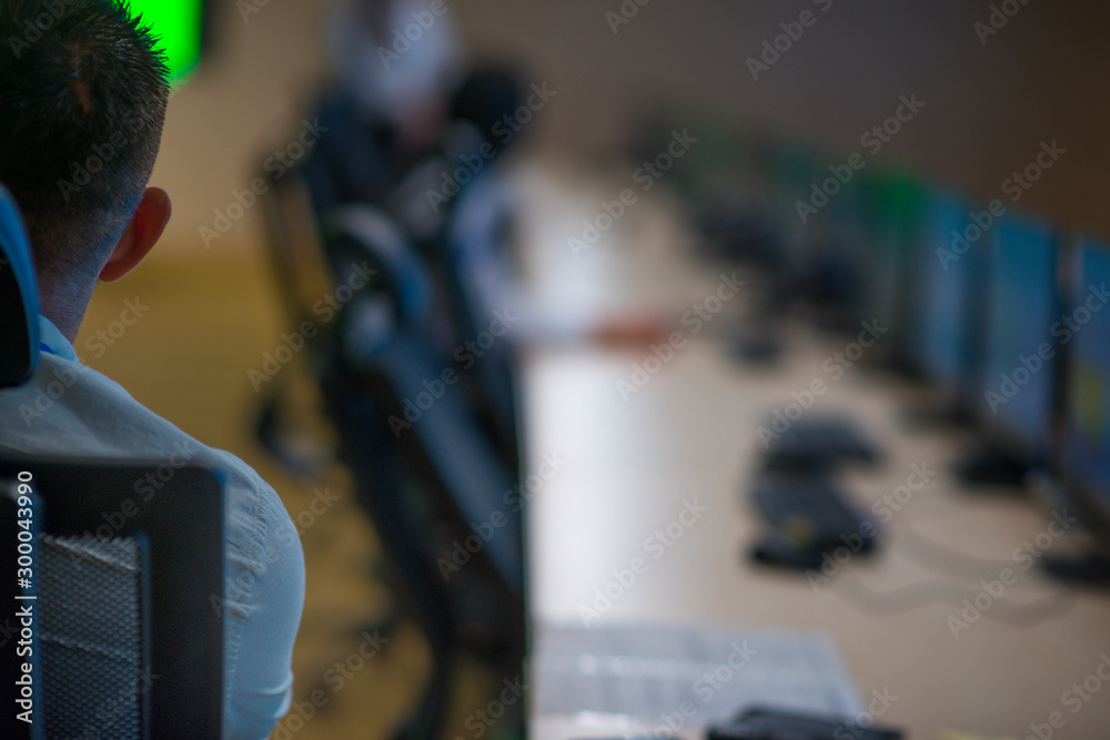 Obraz premium Security guard monitoring modern CCTV cameras in a surveillance room.