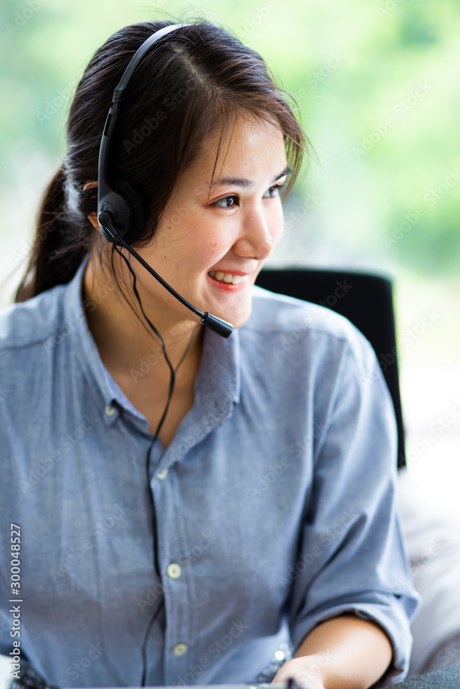 Attractive business woman Asian in suits and headsets are smiling while working with computer at office. Customer service assistant working in office Attractive business woman Asian in suits and headsets are smiling while working with computer at office. Customer service assistant working in office