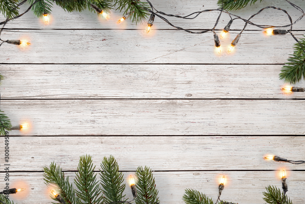 Christmas lights bulb and pine leaves decoration on white wood plank, frame  border design. Merry Christmas and New Year holiday background. top view.  Stock Photo | Adobe Stock