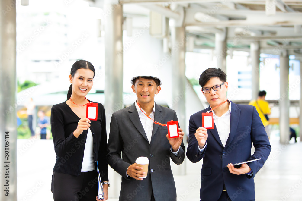 Engineering and architecture concept. Team of professional engineers working working on site and show the Company employee red Card Engineering and architecture concept. Team of professional engineers working working on site and show the Company employee red Card