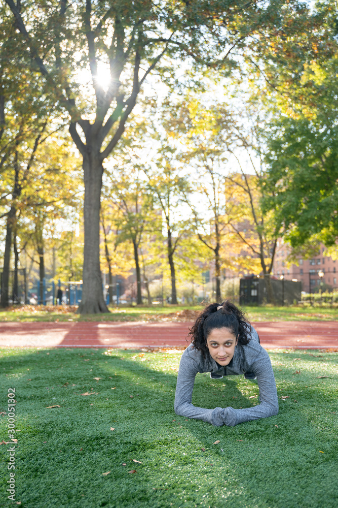 Athletic female doing planks at the track