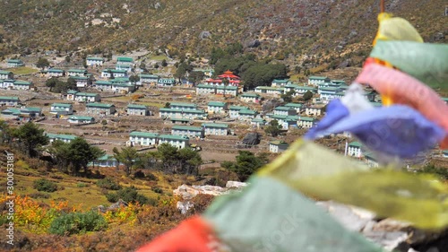 Khumjung village on the way to Mount Everest, static handled shot, focus move from prayer flags to village view photo