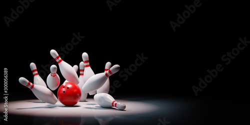 Slika na platnu Bowling Strike of Skittles Spotlighted on Black Background