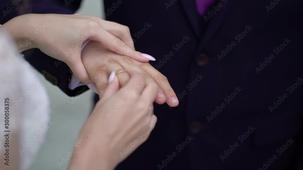 Bride and groom exchange wedding rings at ceremony. Lovely couple.