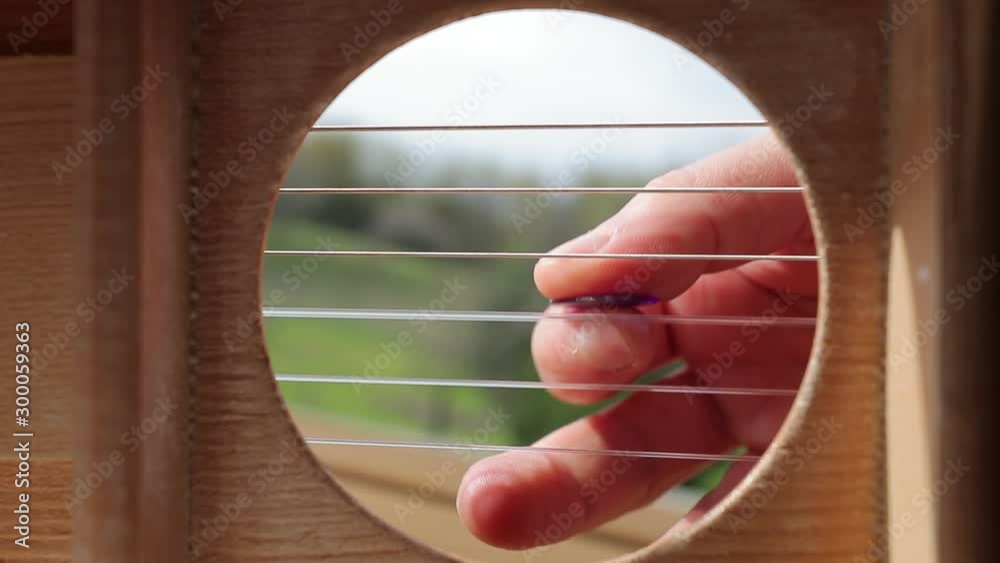 Perspective String Playing acoustic guitar viewed from the inside, strumming chords with ...