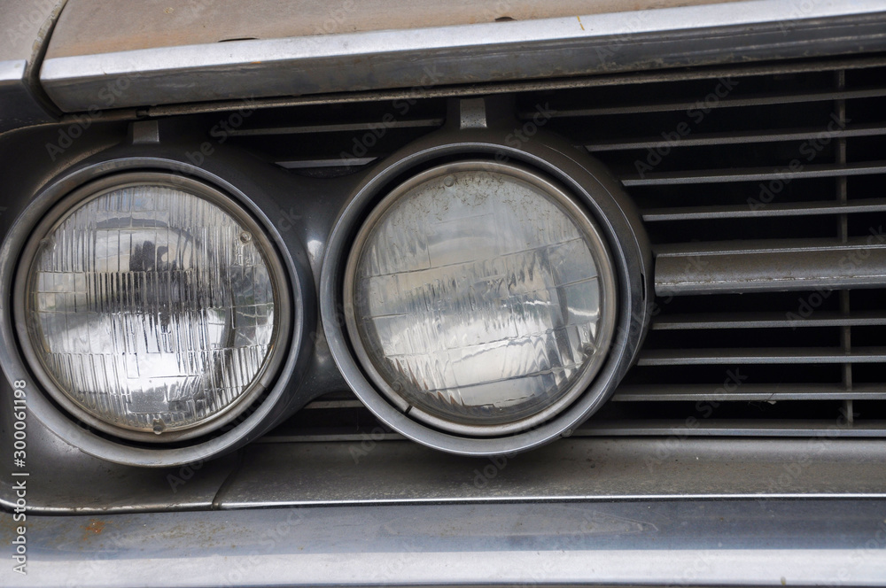 Close up of one side of double round headlights on an old classic car Close up of one side of double round headlights on an old classic car