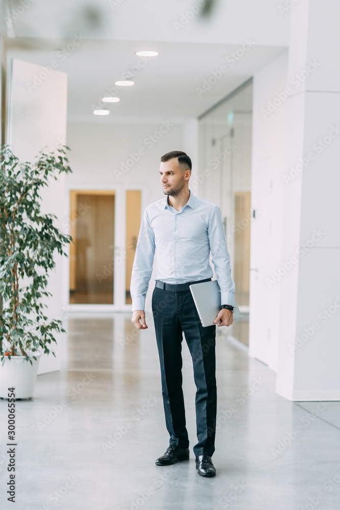 Walking around the business center. Portrait of a young successful man in motion. Walking around the business center. Portrait of a young successful man in motion.